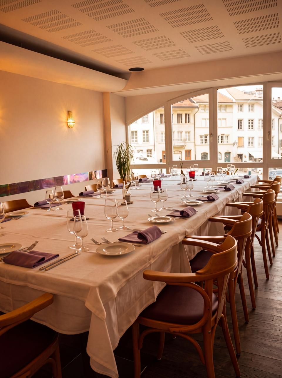 La salle des arcades, tables en longueur sous les baies cintrées