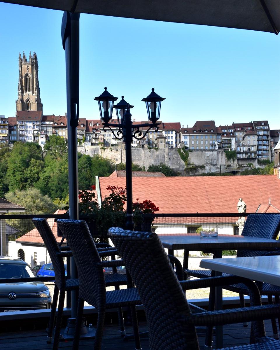Table dressée en terrasse, cathédrale de Fribourg en arrière-plan